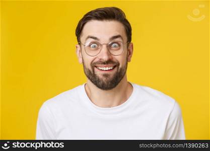 Young man looking at copyspace having a surprised or satisfied look isolated on yellow background. Young man looking at copyspace having a surprised or satisfied look isolated on yellow background.