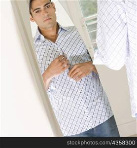 Young man looking at himself in a mirror