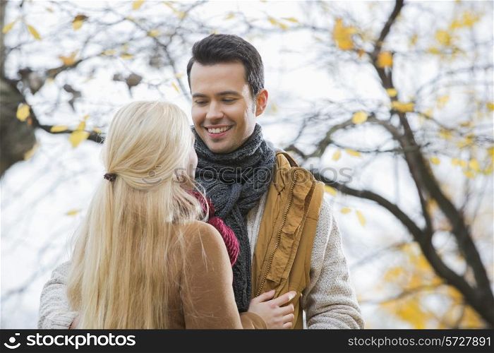 Young man looking at woman in park during autumn