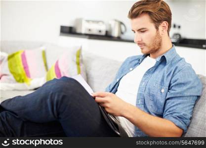 Young Man Looking Through Personal Finances At Home