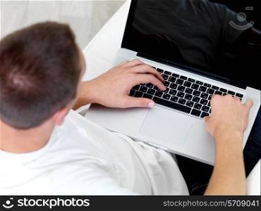 young man looks in the laptop at home - high angle