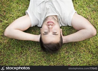 Young man lying and relaxing in grass