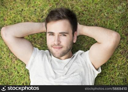 Young man lying and relaxing in grass