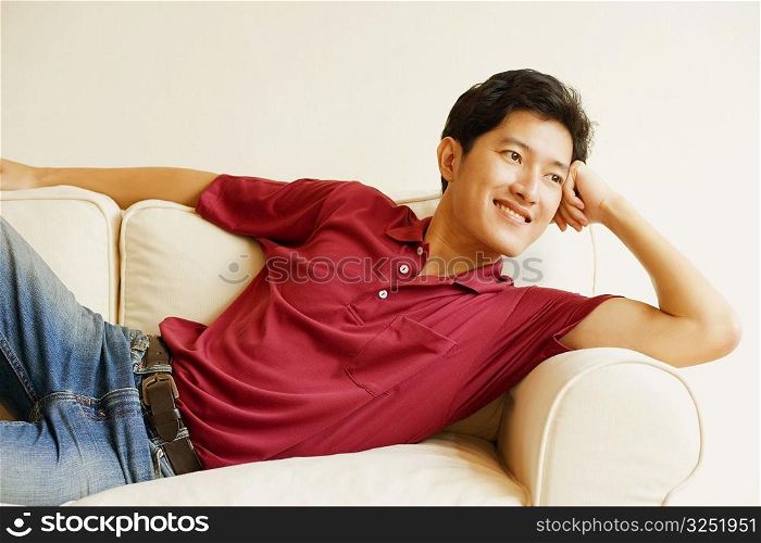Young man lying on a couch and smiling