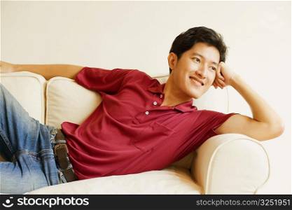 Young man lying on a couch and smiling