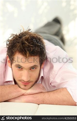 Young man lying on a sofa