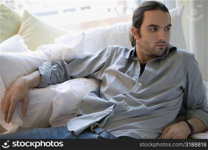 Young man lying on the bed and thinking
