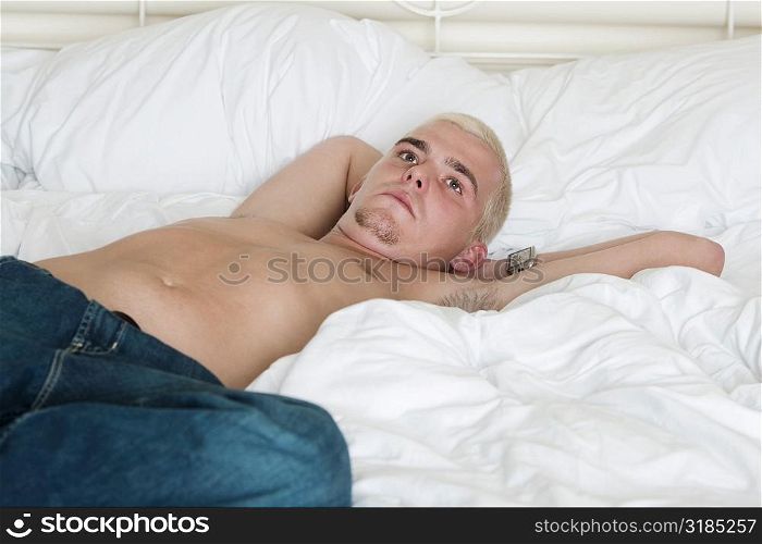 Young man lying on the bed looking up