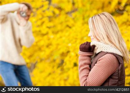 Young man make photo of posing woman profile in autumn park