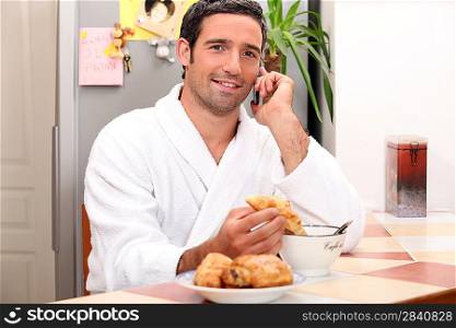 young man making a call while having breakfast