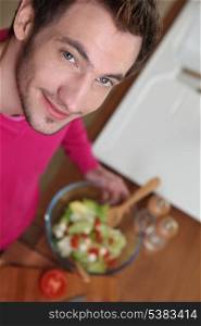 Young man making a salad