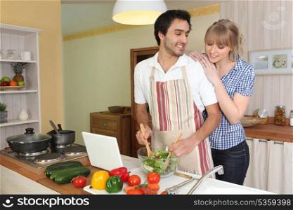 Young man making a salad with his partner