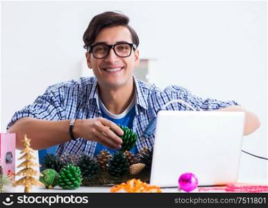 Young man making christmas decoration from cones. The young man making christmas decoration from cones