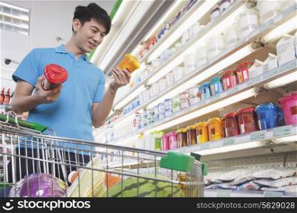 Young Man Making Decisions About Food in Supermarket