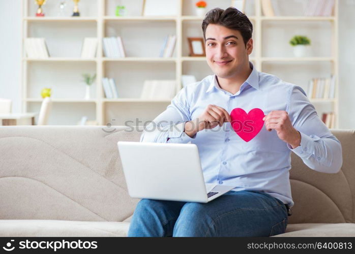 Young man making marriage proposal over internet laptop