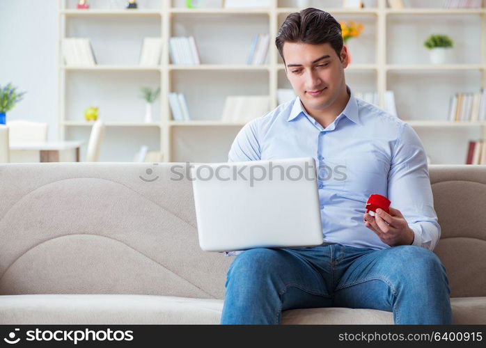 Young man making marriage proposal over internet laptop