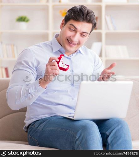 Young man making marriage proposal over internet laptop. The young man making marriage proposal over internet laptop