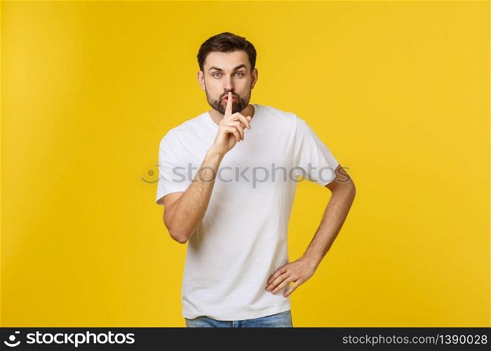 young man making silence gesture, shhhhh. Isolated over yellow background. young man making silence gesture, shhhhh. Isolated over yellow background.