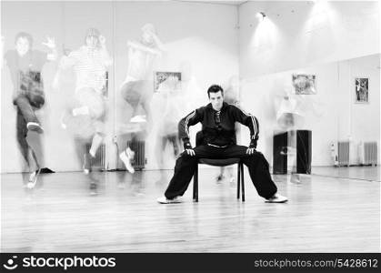 young man meditating in lotus position at dance studio