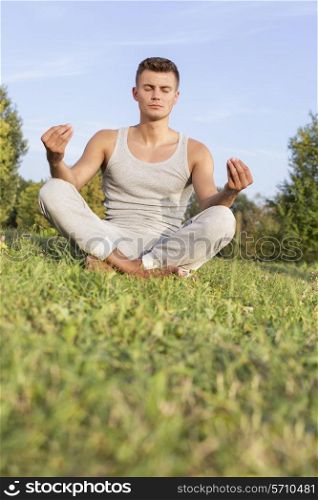 Young man meditating in park