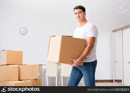 Young man moving boxes at home