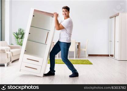 Young man moving furniture at home