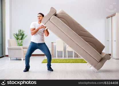 Young man moving furniture at home