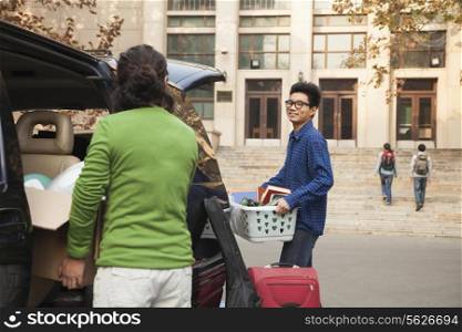 Young man moving into dormitory on college campus