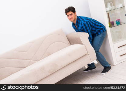 Young man moving sofa couch