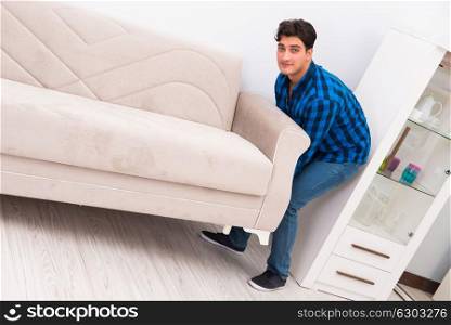 Young man moving sofa couch