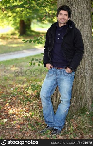 young man near a tree in autumn