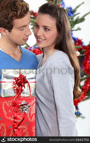 Young man offering gift to his girlfriend for Christmas