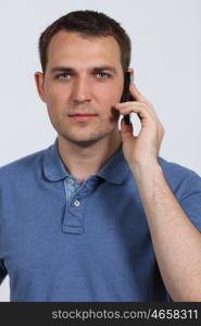 young man on his mobile phone against a white background