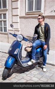 Young man on scooter outdoors on the old european city. Young man background the old european city take selfie