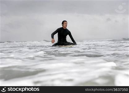 Young man on surfboard in ocean