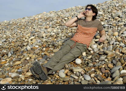 young man on the beach with cell phone