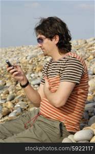 young man on the beach with cell phone