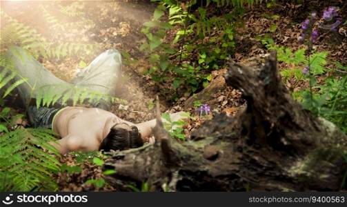 Young man on the floor of a forest