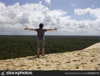 young man on the top of dune in pylat sur mer, france