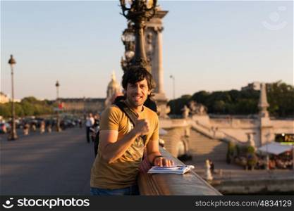 Young man on vacations in Paris, relaxing over the Alexander the 3rd bridge