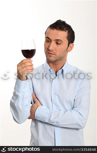 Young man on white background tasting red wine