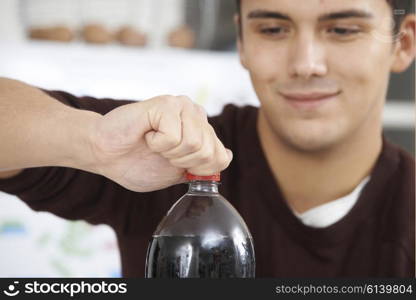 Young Man Opening Bottle Of Soda
