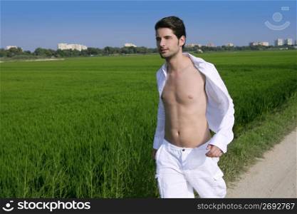 Young man outdoor running in a green rice field meadow