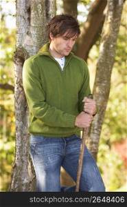 Young Man Outdoors Walking In Autumn Woodland Holding Walking Stick