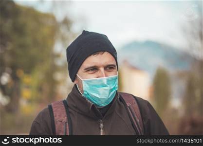 Young man outdoors wearing a face mask. Corona and flu season.
