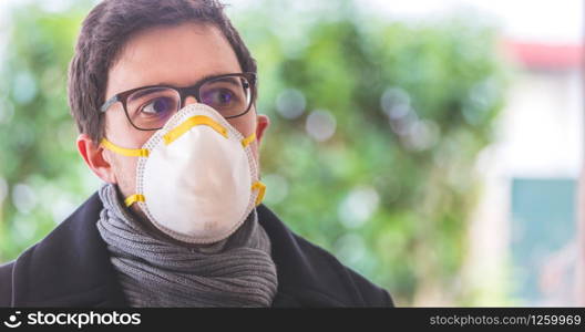 Young man outdoors with a breathing mask. Flue and corona season.