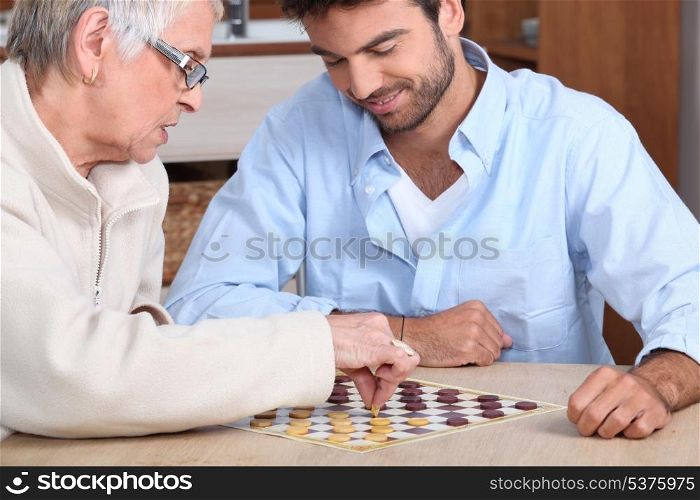 Young man paying game with old lady