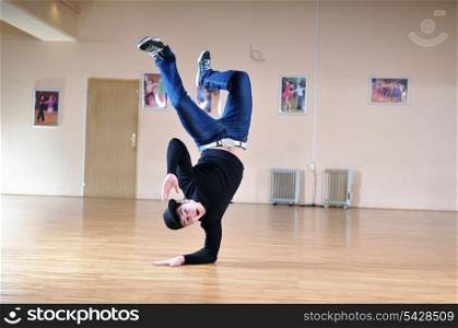 young man performing break dance in dance studio