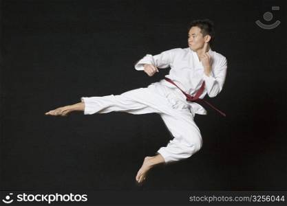 Young man performing flying kick