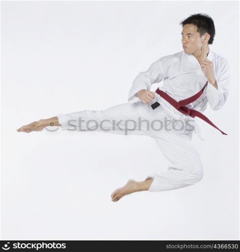 Young man performing flying kick
